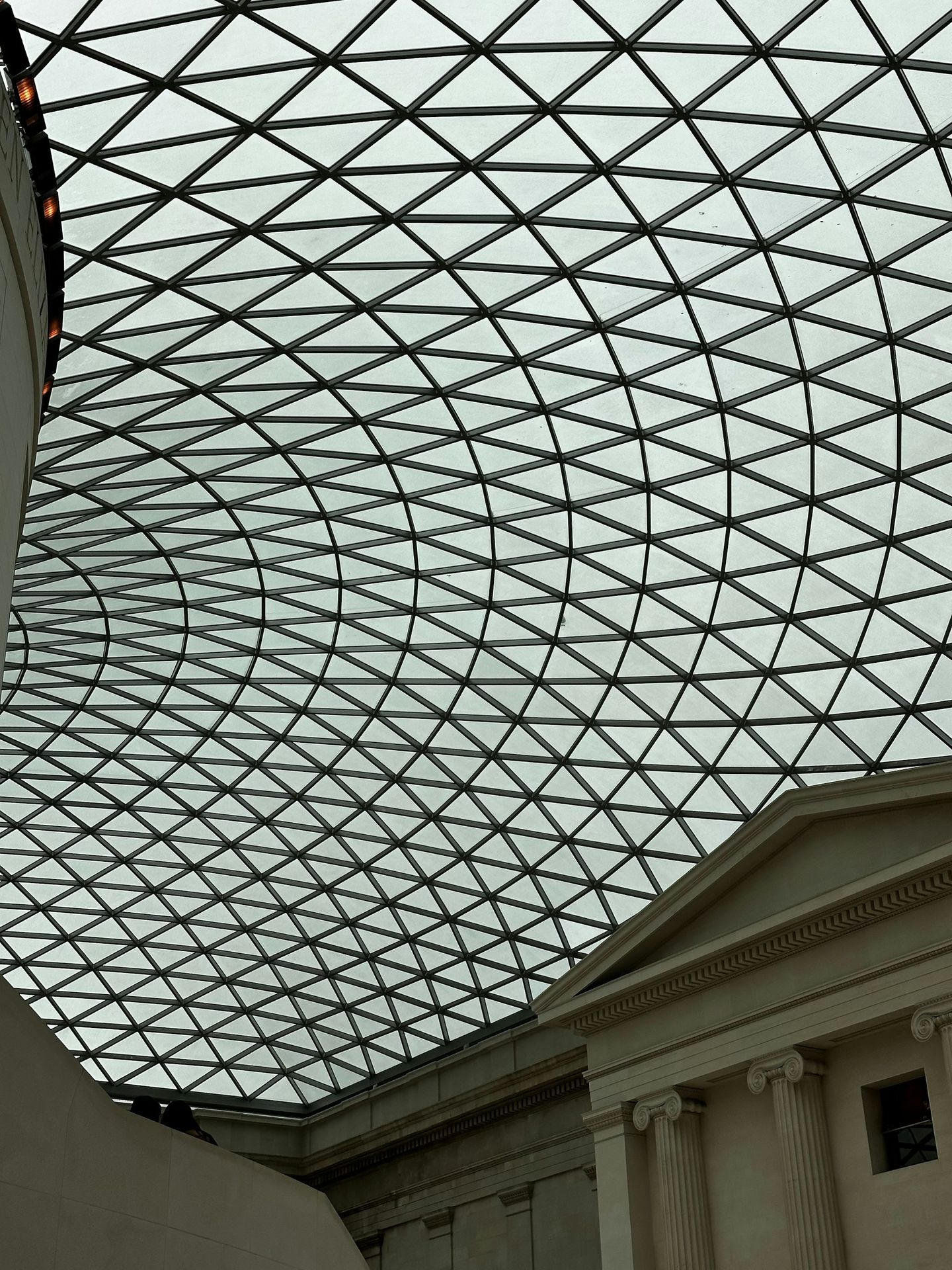 Geometric glass ceiling above classical architecture